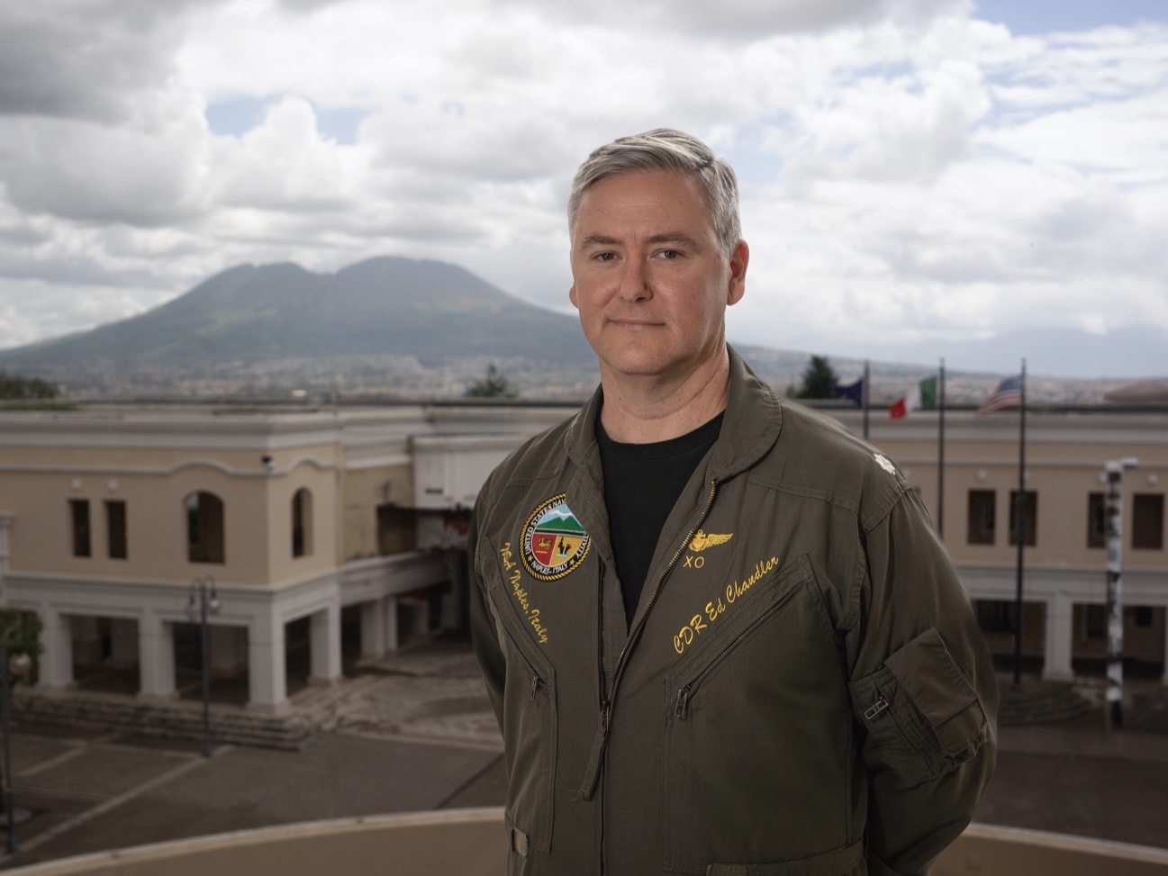 Ed Chandler in Naples, Italy, with Mount Vesuvius behind him, while leading at NATO and U.S. Navy headquarters in Europe